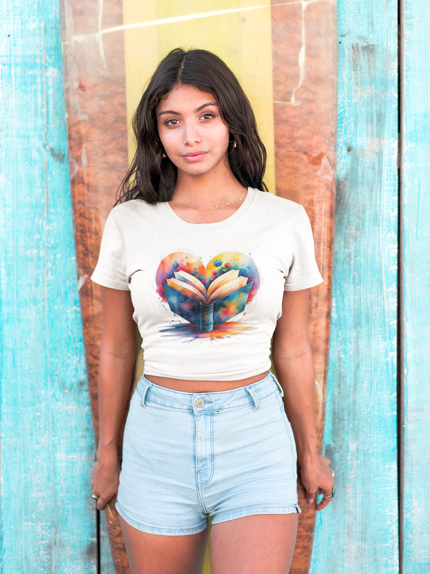 Woman wearing a white t-shirt with a colorful heart design against a wooden background.
