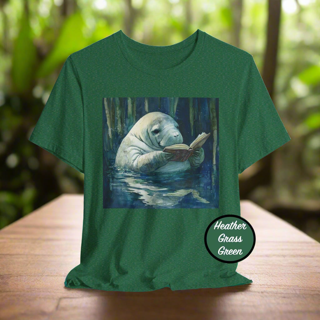 Green t-shirt with a manatee reading a book graphic on a white background