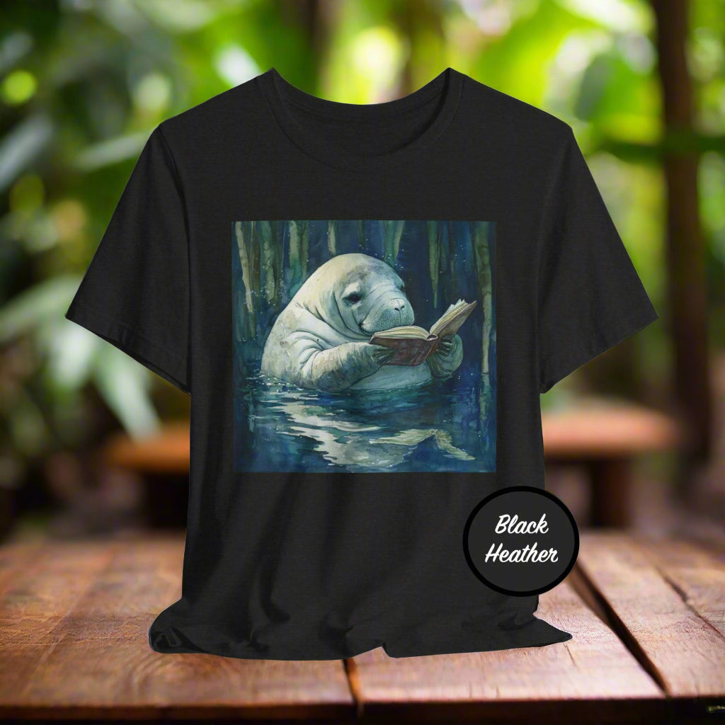 Black t-shirt with a manatee reading a book graphic on a white background