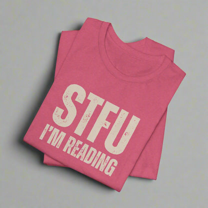 Pink t-shirt with 'STFU I'm Reading' text on a white background