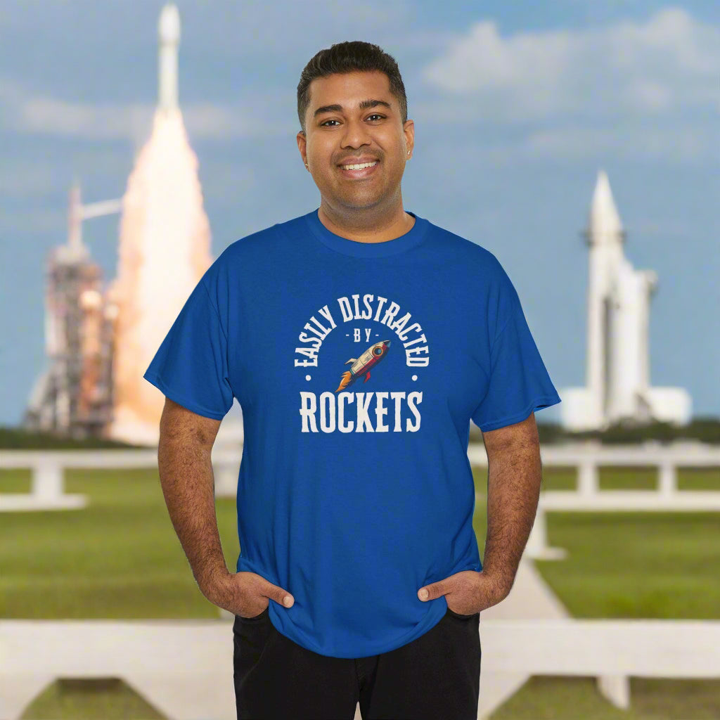 Man wearing a blue t-shirt with 'Easily Distracted by Rockets' text and graphic on a white background
