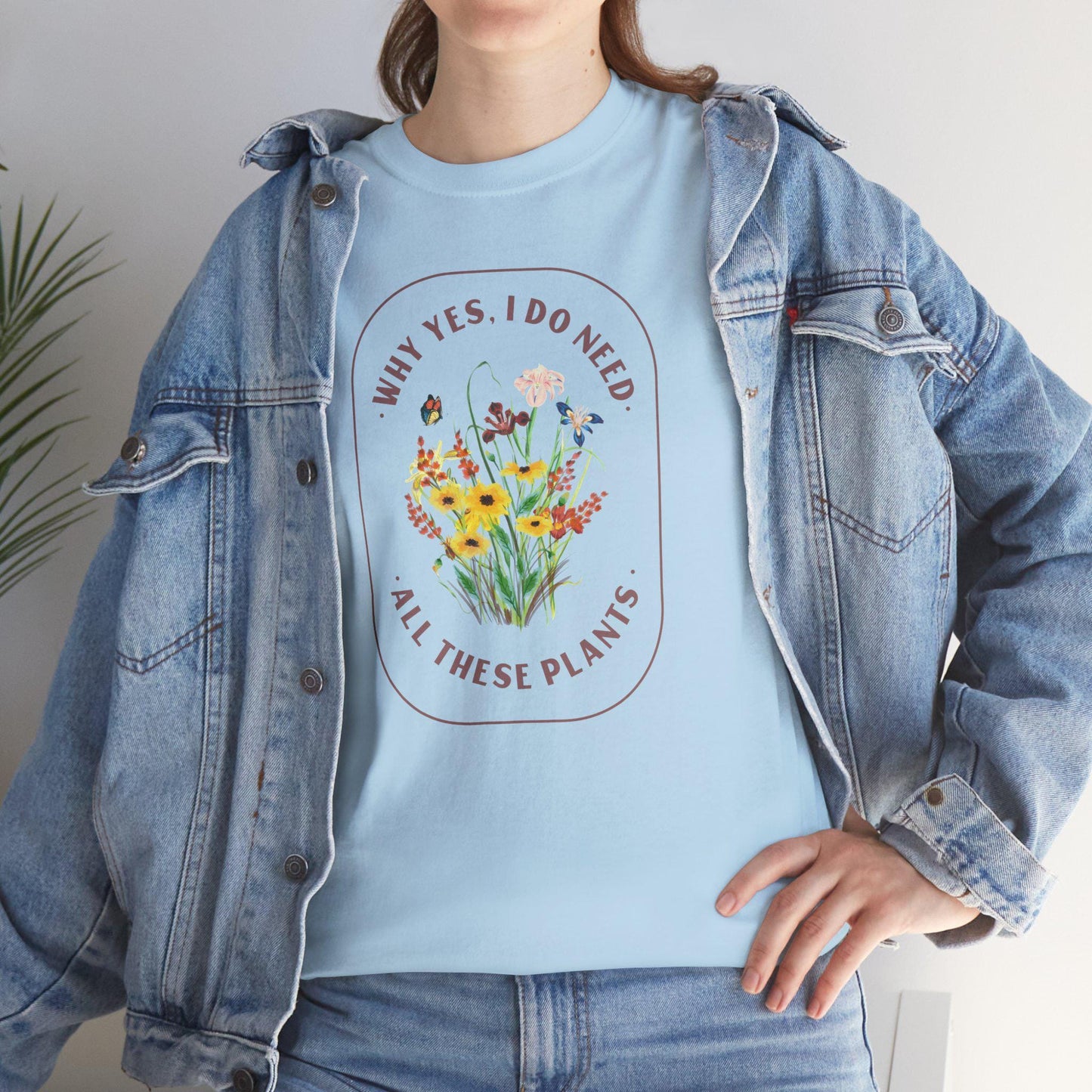 Person wearing a light blue t-shirt with floral design and text, paired with a denim jacket.
