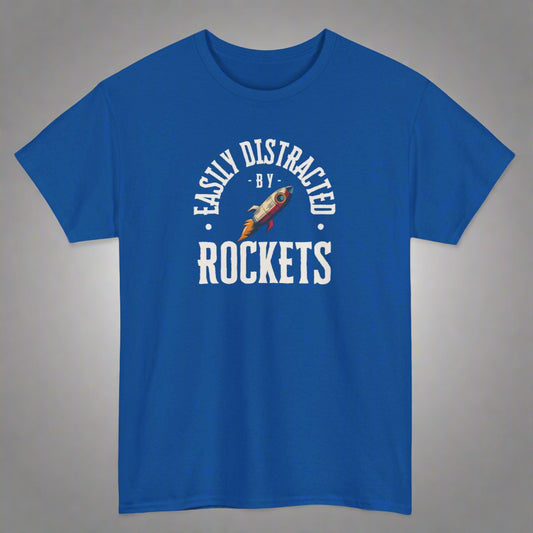 Blue t-shirt with 'Easily Distracted by Rockets' text and rocket graphic on a white background