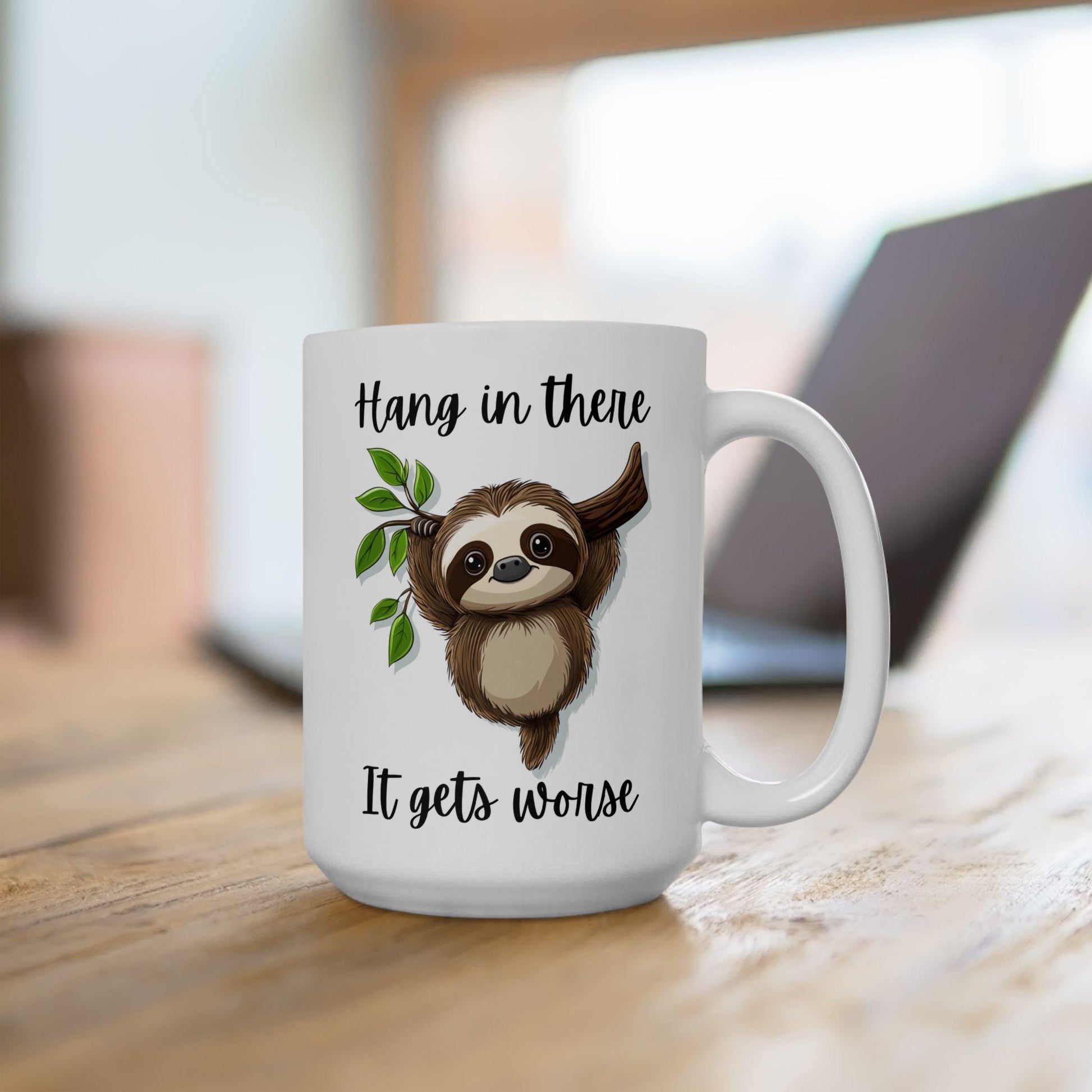 White mug with a sloth illustration and text on a wooden surface
