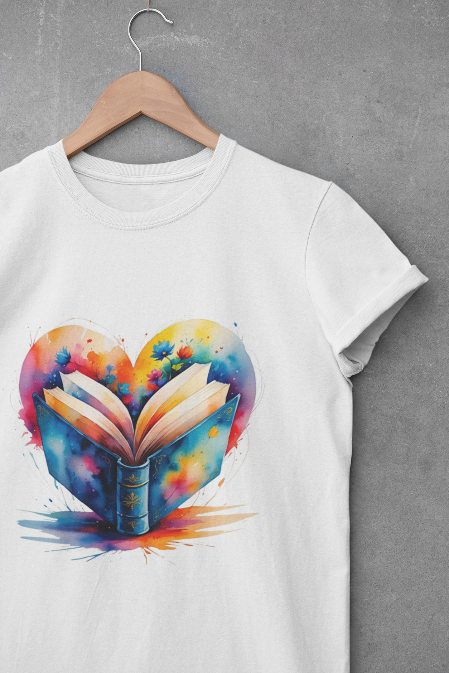 White t-shirt with a colorful heart-shaped book design on a hanger against a gray background