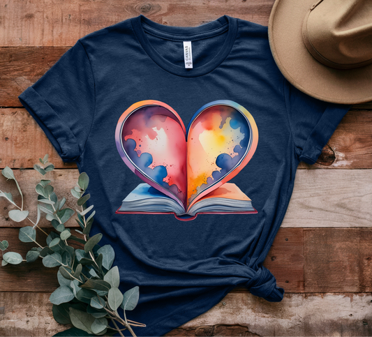 Navy blue t-shirt with a colorful heart design on a wooden surface with a hat and plant.