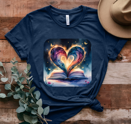 Navy blue t-shirt with a heart-shaped book design on a wooden surface with a hat and plant.
