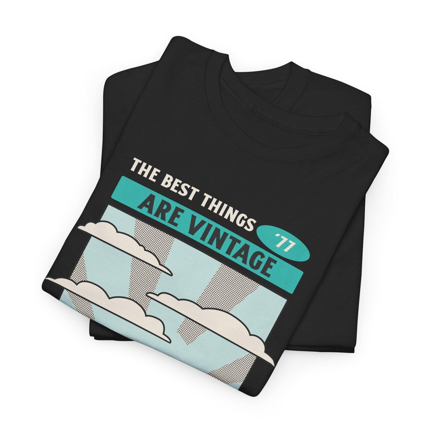 Folded black t-shirt with 'The best things are vintage' text and cloud design on a white background