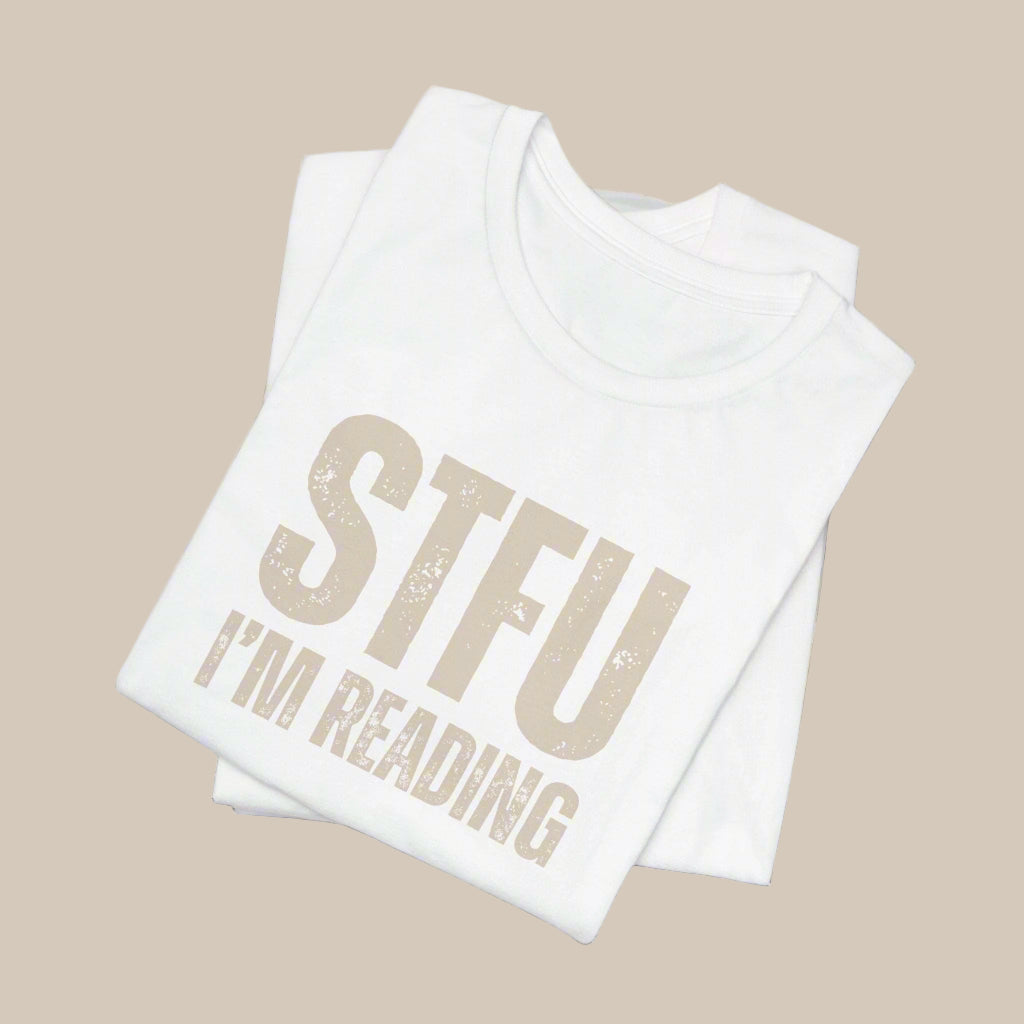 White shirt with 'STFU I'm Reading' text in gold on a white background