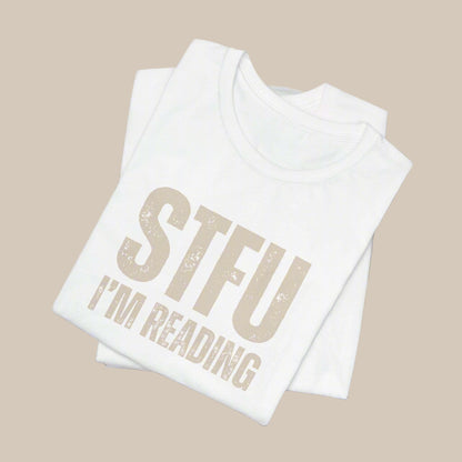 White shirt with 'STFU I'm Reading' text in gold on a white background