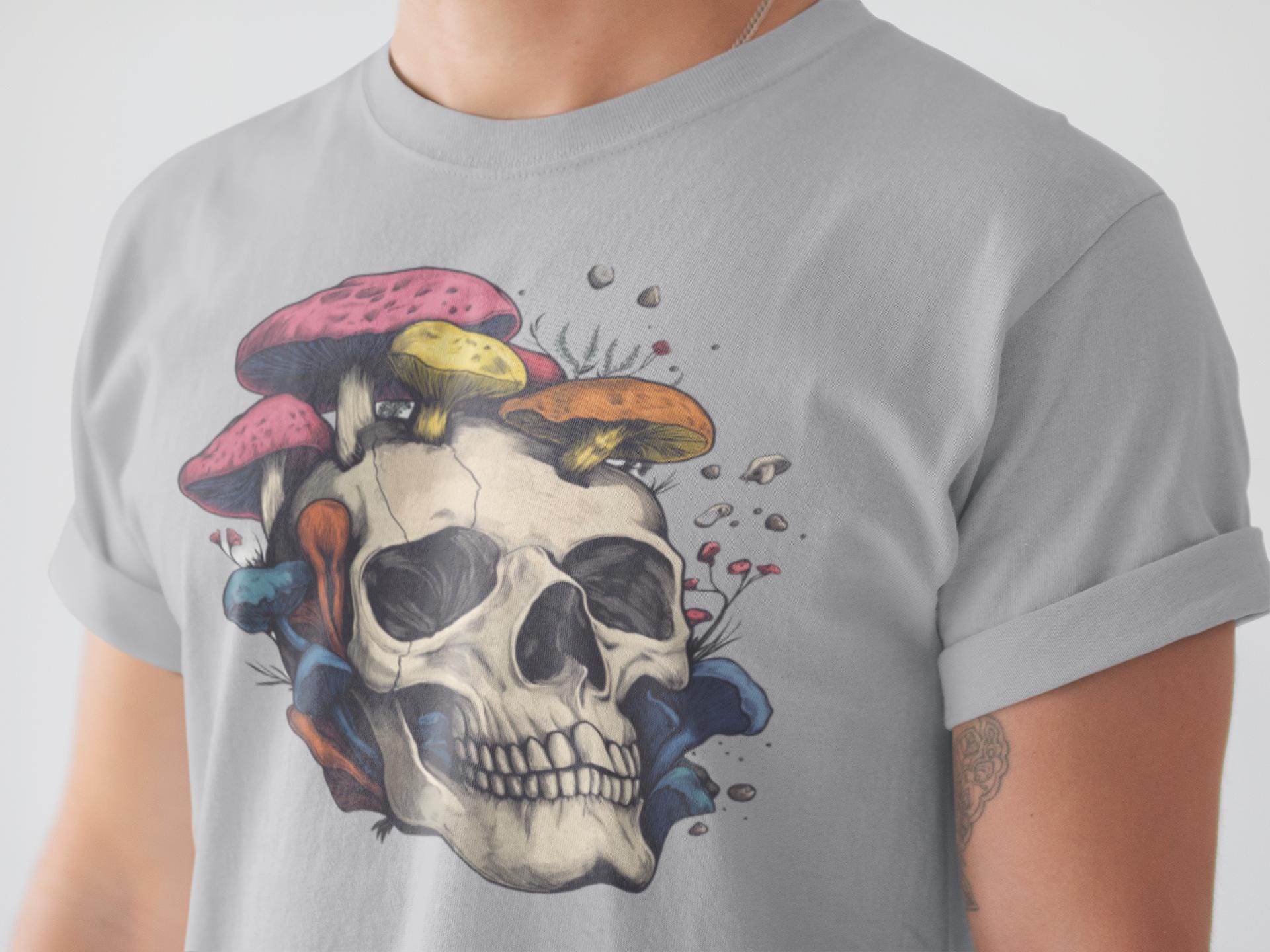 Gray t-shirt with a skull and colorful mushrooms design on a plain background