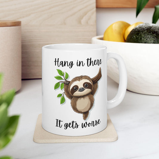 White mug with a sloth illustration and text on a wooden coaster.