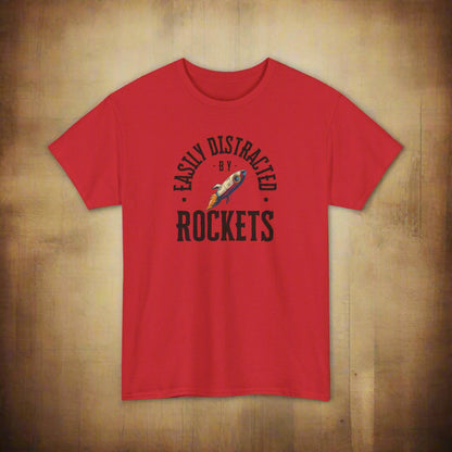 Red t-shirt with 'Easily Distracted by Rockets' graphic on a white background