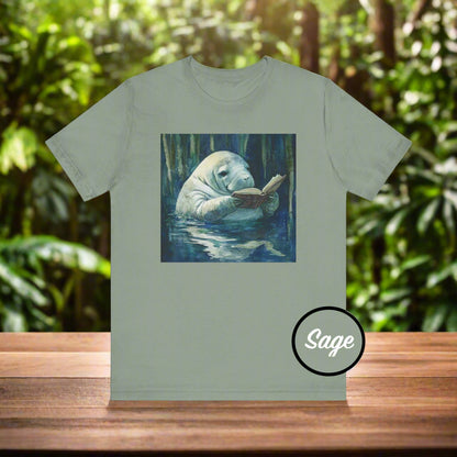 Sage green t-shirt with a manatee reading a book graphic on a white background