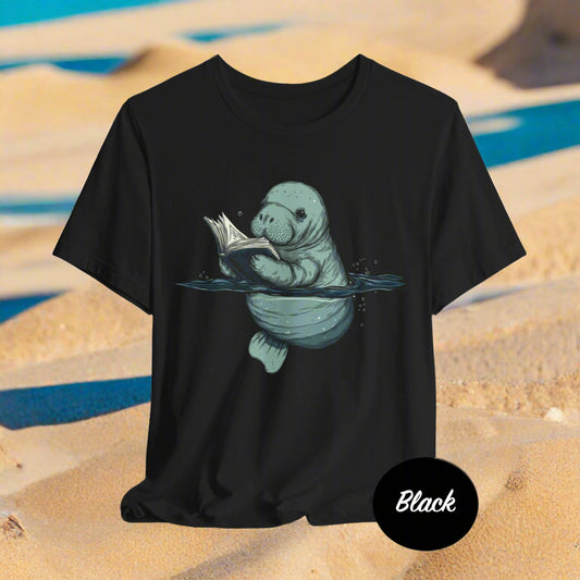 Black t-shirt with a graphic of a manatee reading a book on a white background