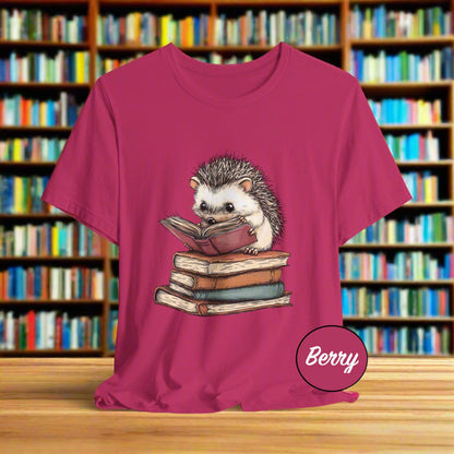 Pink t-shirt with a hedgehog reading a book graphic on a white background