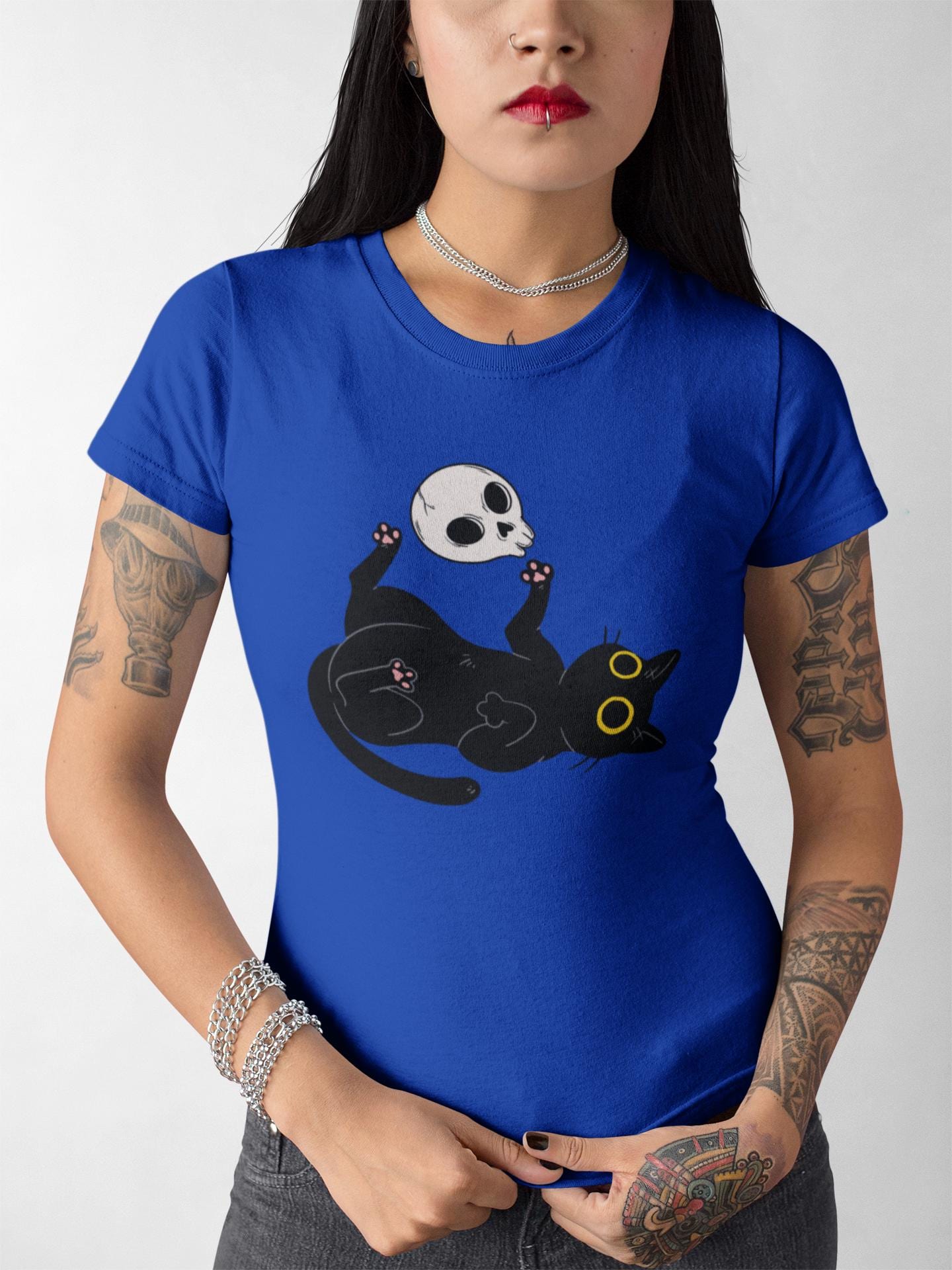 Person wearing a blue t-shirt with a black cat and skull design.