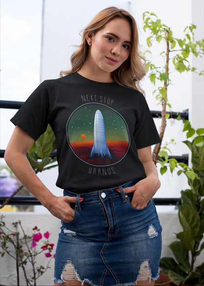 Woman wearing a black t-shirt with a space-themed design, standing outdoors with plants in the background.