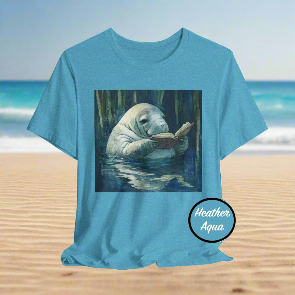 Blue t-shirt with a manatee reading a book graphic and 'Heather Aqua' label on a white background