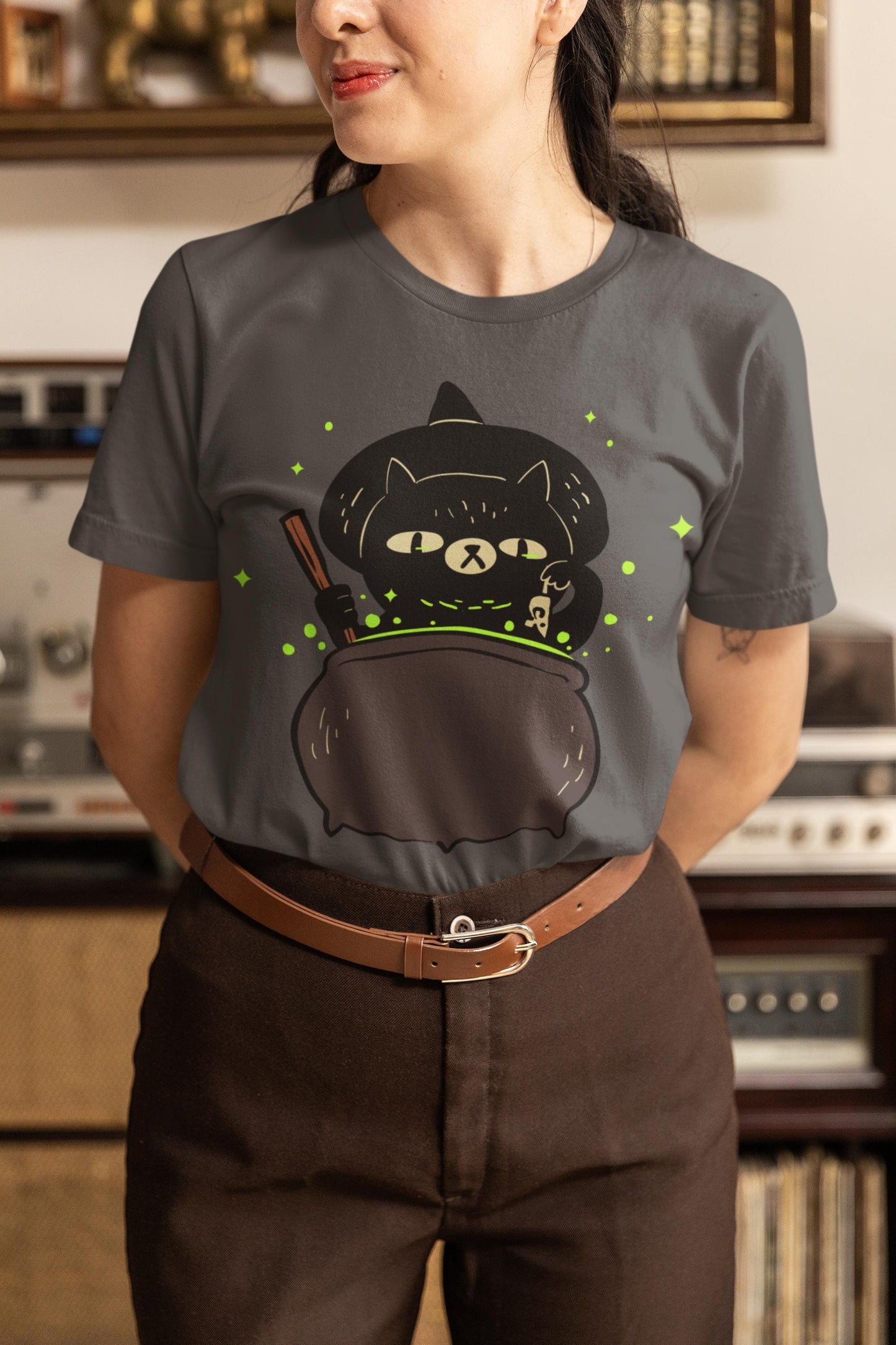 Person wearing a dark gray t-shirt with a graphic design in a room with vintage equipment.