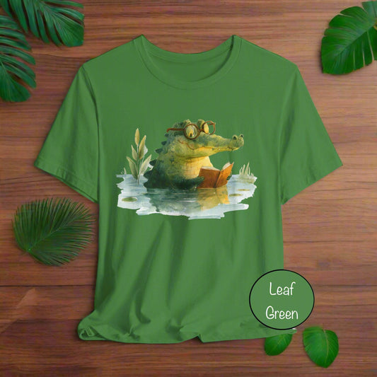 Green t-shirt with a crocodile reading a book graphic on a white background