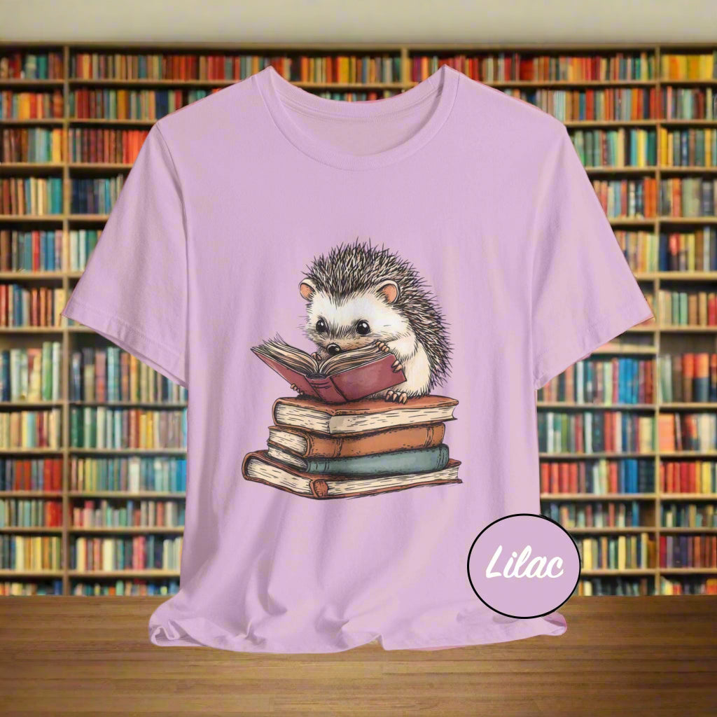 Lilac t-shirt with a hedgehog reading a book graphic on a light purple background