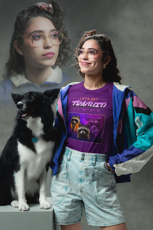 Woman in a purple graphic t-shirt and denim shorts standing next to a black and white dog, with a gray background.