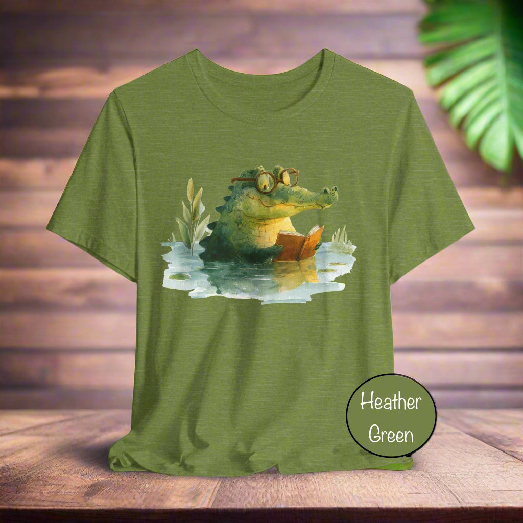 Green t-shirt with a crocodile reading a book graphic on a white background