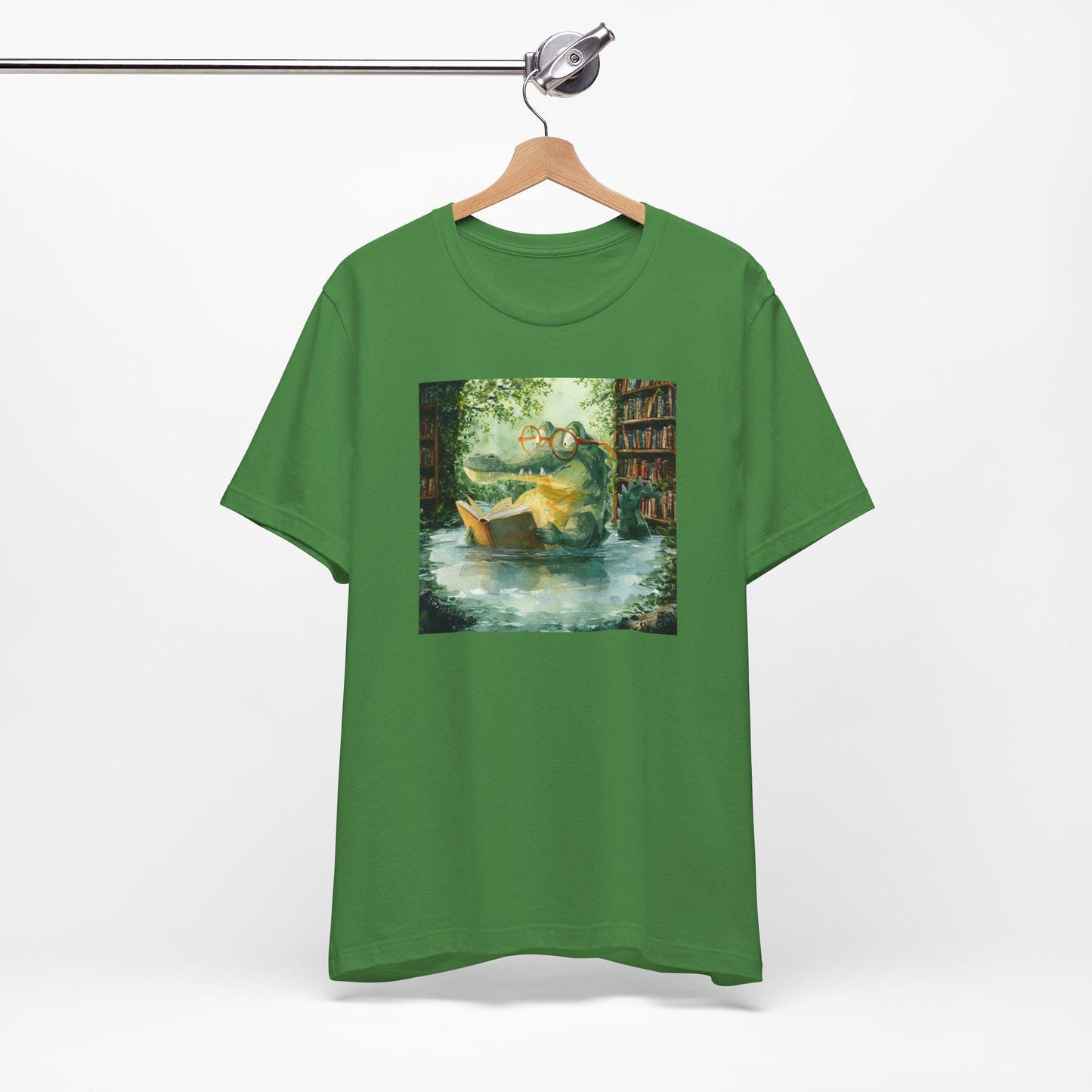 Green t-shirt with a printed design of a boat and books on a hanger against a white background