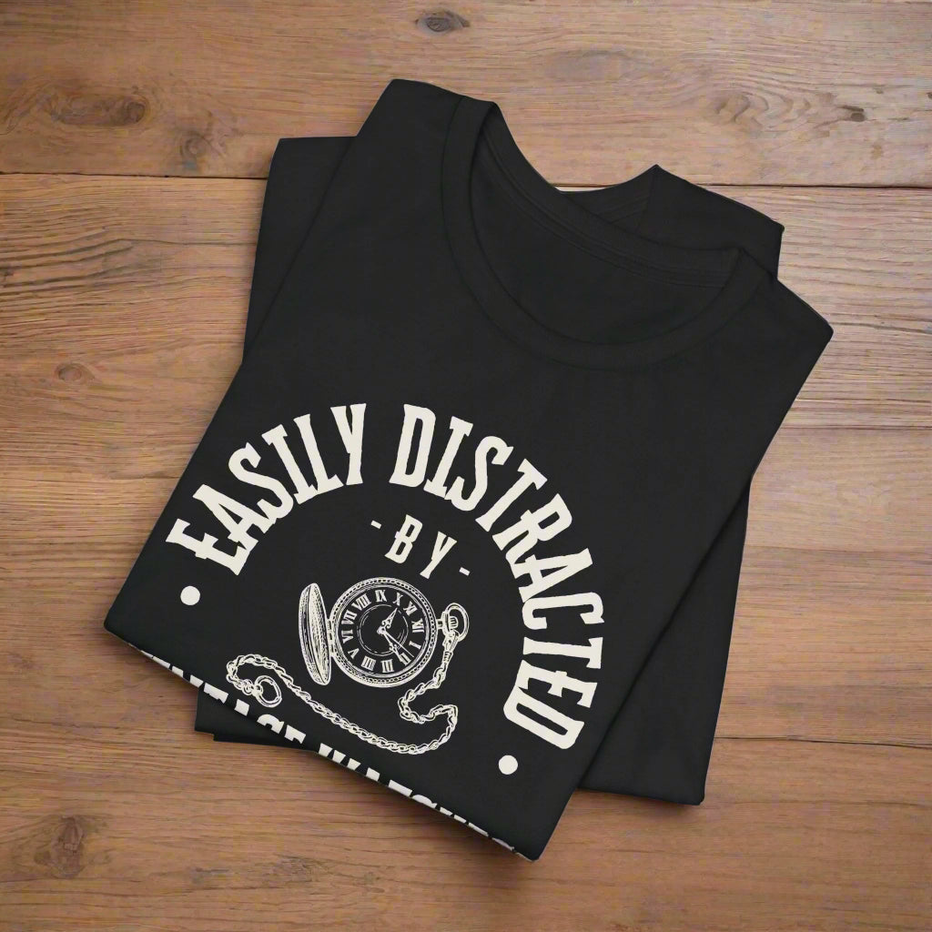 Black t-shirt with 'Easily Distracted' text on a wood floor background