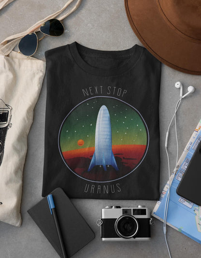 Black sweatshirt with space-themed design on a gray surface with accessories.